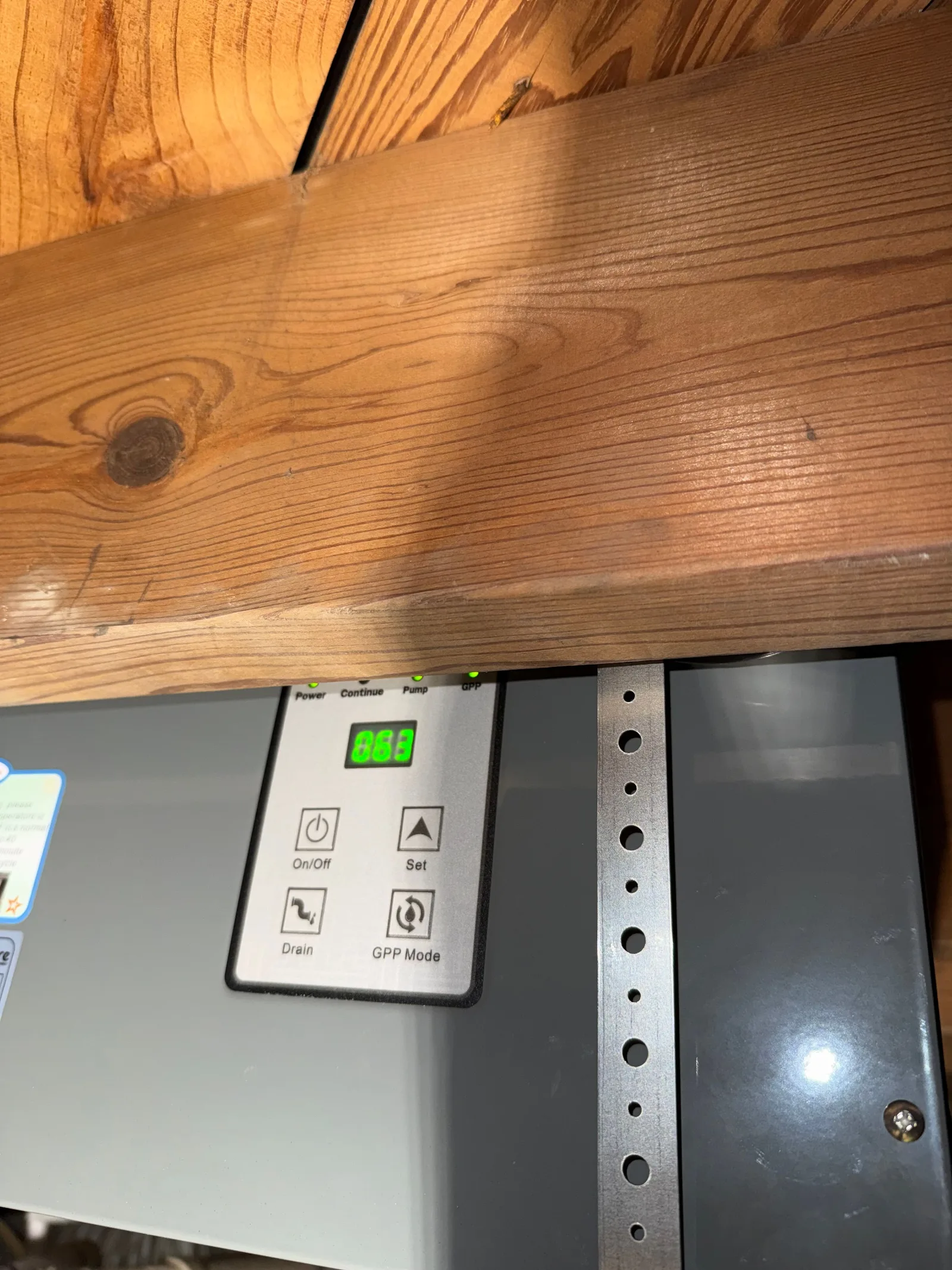 Close-up of a crawlspace dehumidifier control panel with a green digital display showing "663", buttons for On/Off, Set, Drai